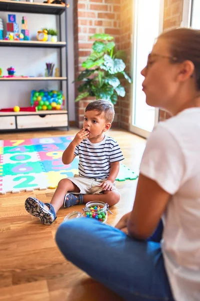 Beautiful Teacher Toddler Boy Sitting Eating Small Chocolate Balls Kindergar — ストック写真