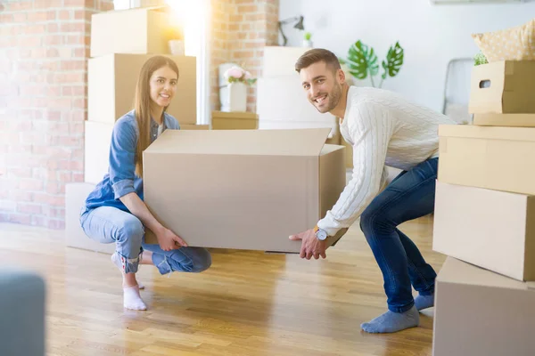 美丽的年轻夫妇搬到一个新的家 拿着大纸板箱 — 图库照片