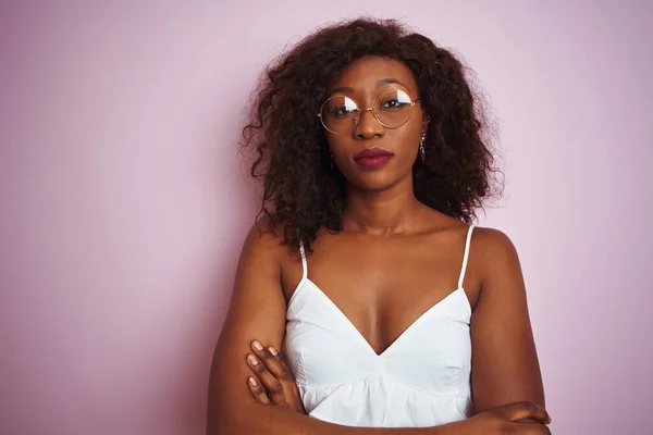 年轻的非洲裔美国女人戴着眼镜 站在孤立的粉色背景下 怀疑而紧张 双手交叉 脸上带着不赞成的表情 消极的人 — 图库照片
