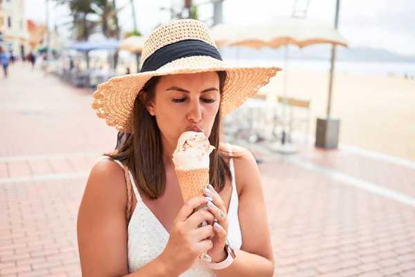 夏の晴れた日の休日にビーチでアイスクリームコーンを食べる若い美しい女性 — ストック写真