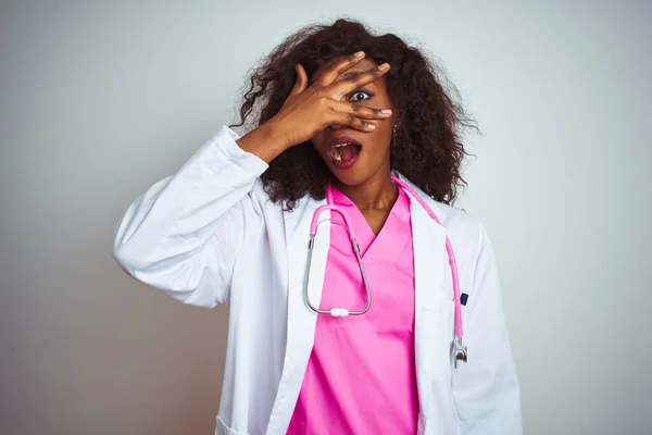 Médico Afroamericano Con Estetoscopio Rosa Sobre Fondo Blanco Aislado Asomándose — Foto de Stock