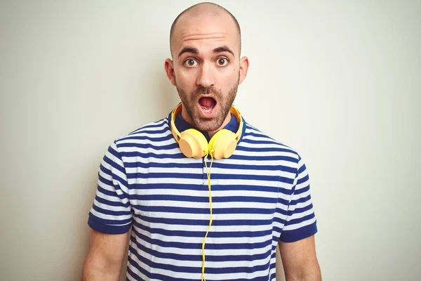 Joven Escuchando Música Con Auriculares Amarillos Sobre Fondo Aislado Asustado — Foto de Stock