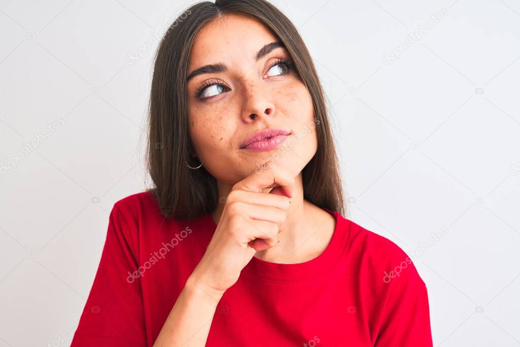 Young beautiful woman wearing red casual t-shirt standing over isolated white background serious face thinking about question, very confused idea