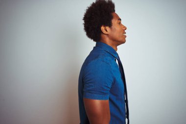 Afro saçlı, mavi gömlekli ve kravatlı Amerikalı bir iş adamı. İzole edilmiş beyaz arka planı var. Yan tarafa bakıyor..