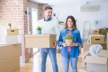 Karton kutuların etrafında duran genç ve güzel bir çift. 