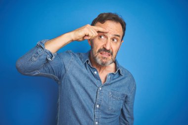 Yakışıklı, orta yaşlı, gri saçlı, mavi arka planda yaşayan, alnında sivilce olmayan, çirkin bir siyah nokta enfeksiyonu olan yaşlı bir adam. Sivilce ve deri problemi