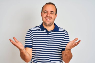 Sıradan çizgili polo giyen genç adam izole edilmiş beyaz arka planda gülümseyen ve yardım eli uzatan ve kabul gören biri..