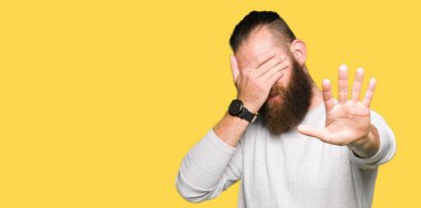 Genç sarışın adam elleriyle gözlerini kapsayan geçici kazak giyen ve stop jest ile acı ve korku ifadesi. Utandım ve negatif kavramı.