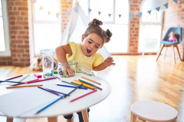 Όμορφο Μικρό Παιδί Στέκεται Παίζει Σοκολάτα Χρωματιστές Μπάλες Στο Τραπέζι — Φωτογραφία Αρχείου