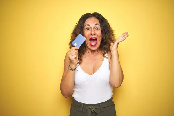 Middle Age Senior Woman Holding Credit Card Yellow Isolated Background — 图库照片