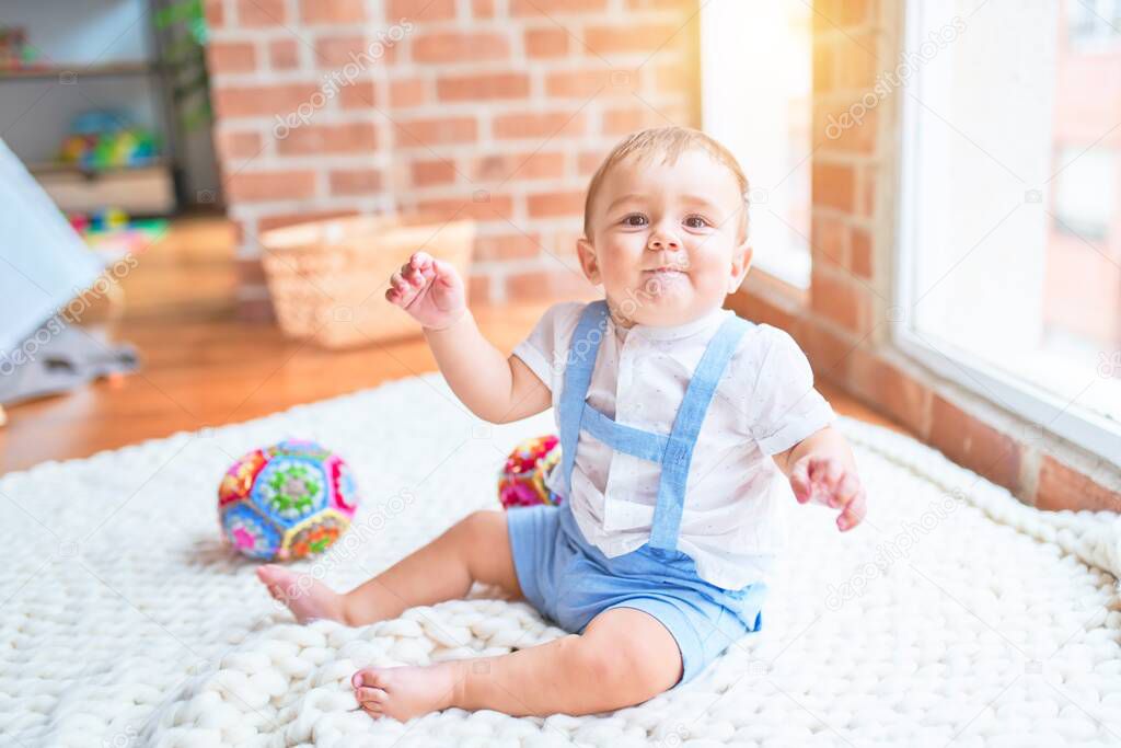 Beautiful toddler sitting on the blanket at kindergarten