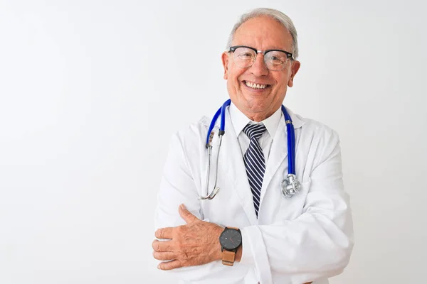 独立した白い背景の上に立って聴診器を身に着けているシニア白髪の医者の男は カメラを見て交差腕で笑顔 正の人 — ストック写真