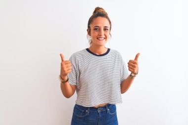 Genç kızıl saçlı modern kadın, izole edilmiş arka plan başarı işareti üzerine çörek giyip elleriyle olumlu jest yapıyor, gülümsüyor ve mutlu. Neşeli ifade ve kazanan jest.