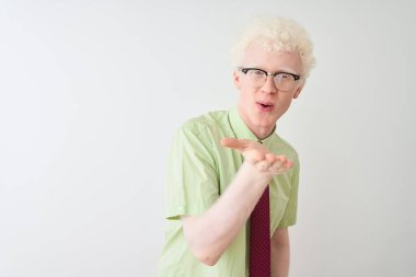 Genç albino işadamı gömlek ve kravat giyerek izole edilmiş beyaz arka planda dikilip kameraya bakarak havada el sallayarak bir öpücük savuruyor. Güzel ve seksi. Aşk ifadesi.