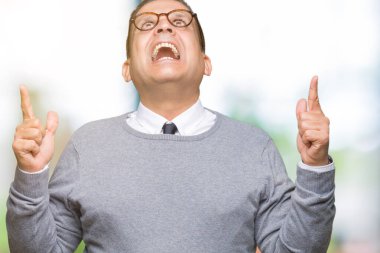 Orta yaş bussines Arap adam izole arka plan üzerinde gözlük hayret ve yukarıya bakıp parmakları ile işaret şaşırttı ve silah kaldırdı.