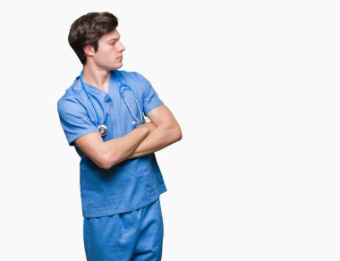 İkna ve kendine güvenen genç doktor tarafına silahlarla seyir gülümseyen izole arka plan üzerinde tıbbi üniforma geçti