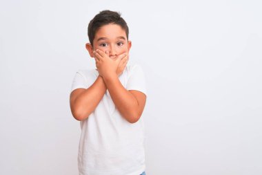 İzole edilmiş beyaz arka plan üzerinde sıradan tişörtler giyen güzel çocuk yanlışlıkla ağızlarını kapatarak şok geçirdi. Gizli konsept.