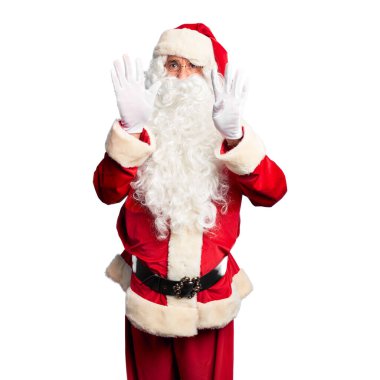 Orta yaşlı yakışıklı, Noel Baba kostümü ve sakal takmış dokuz numaralı parmaklarıyla kendini beğenmiş ve mutlu gülümseyen adam..