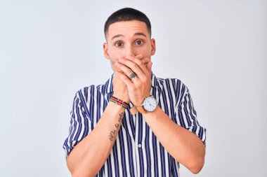Deniz çizgili gömlek giyen genç yakışıklı arka planda dikiliyor. Ağzını yanlışlıkla ellerle kapatıyor. Gizli konsept.