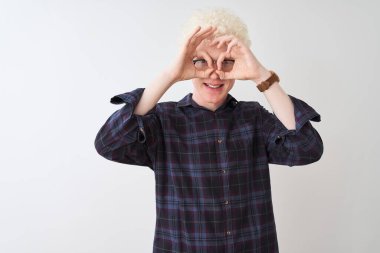 Genç albino sarışın adam, günlük gömlek ve gözlük takıyor, beyaz arka planda, dürbün gibi güzel hareketler yapıyor. Dürbün dilini çıkarıyor, gözler parmaklarından bakıyor. Çılgın ifade.