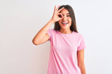 Pembe tişört giyen güzel bir kadın izole edilmiş beyaz arka planda duruyor. El hareketleriyle gülümsüyor, gözleriyle mutlu yüzlere bakıyor..