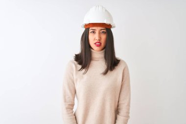 İzole edilmiş beyaz arka plan üzerinde güvenlik kaskı takan genç Çinli mimar kadın yüzünde ciddi bir ifade var. Basit ve doğal bir şekilde kameraya bakıyorsun..