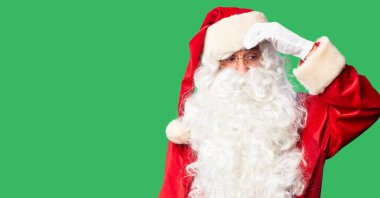 Orta yaşlı yakışıklı adam Noel Baba kostümü ve sakal takmış endişeli ve stresli duruyor.