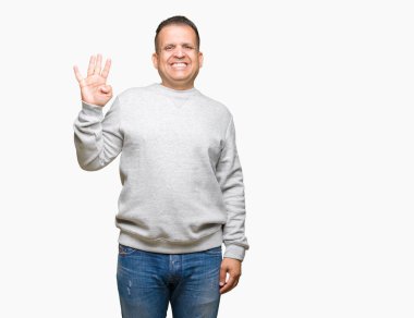 Gösterilen arka plan üzerinde spor kazak giyen orta yaş Arap adam izole ve parmakları ile işaret kendinden emin ve mutlu gülümseyerek süre dört numara.