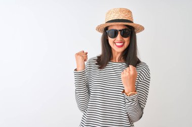 İzole edilmiş beyaz arka planda duran çizgili tişört şapkalı Çinli kadın çok mutlu ve heyecanlı bir şekilde kollarını kaldırıp, gülümseyerek ve başarı için çığlık atarak zafer hareketi yapıyor. Kutlama konsepti.