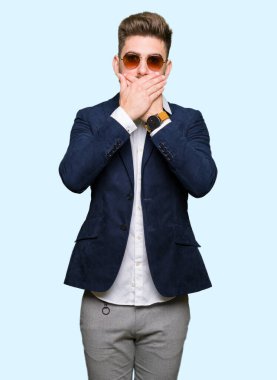 Güneş gözlüğü ve moda ceket ağız hata için elleriyle kapsayan şok giyen genç yakışıklı zarif adam. Gizli kavramı.