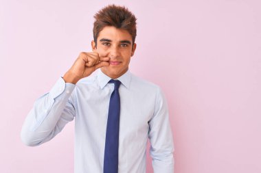 Genç yakışıklı işadamı gömlek giyen ve izole pembe arka plan ağız ve dudakları parmakları ile zip olarak kapalı dudaklar üzerinde duran kravat. Gizli ve sessiz, tabu konuşma