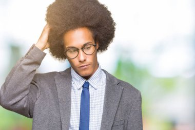 Afro saçlı gözlüklü genç Afro-Amerikalı iş adamı şaşırtmak ve soru hakkında merak ediyorum. Şüphe, kafasına el ile düşünme ile belirsiz. Dalgın kavramı.