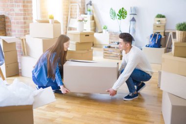 Güzel genç Asyalı Çift mutlu görünümlü, yeni bir eve hareket heyecanlı gülümseyen büyük bir karton kutu tutarak