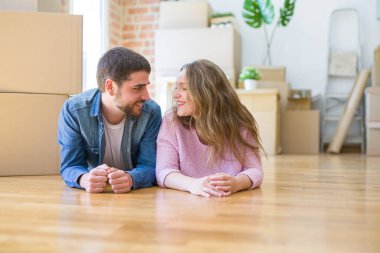 Yeni bir eve taşımak için etrafında karton kutular ile birlikte katta yatarken rahatlatıcı aşk genç güzel çift