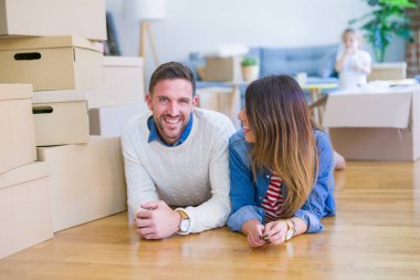 Karton kutular etrafında yeni evde yatan çocuk ile güzel famiily