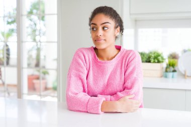 Afro saçlı, sıradan pembe kazak giyen güzel Afro-Amerikalı kadın gülümseyip yan tarafa bakıyor ve şöyle düşünüyor:.