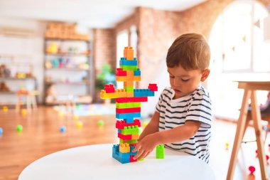 Güzel çocuk anaokulunda inşaat bloklarıyla oynuyor.