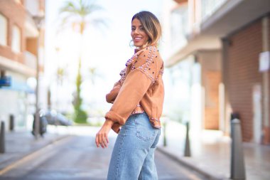 Mutlu ve kendinden emin gülümseyen genç ve güzel bir kadın. Şehir caddesinde ayakta ve yürüyorum.