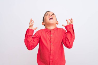 Zarif kırmızı tişört giyen güzel bir çocuk, izole edilmiş beyaz arka planda durmuş, çılgın ve başarının kutlamalarını yapıyor. Kollarını kaldırıp, gözlerini kapatmış heyecanlı çığlıklar atıyor. Kazanan konsept