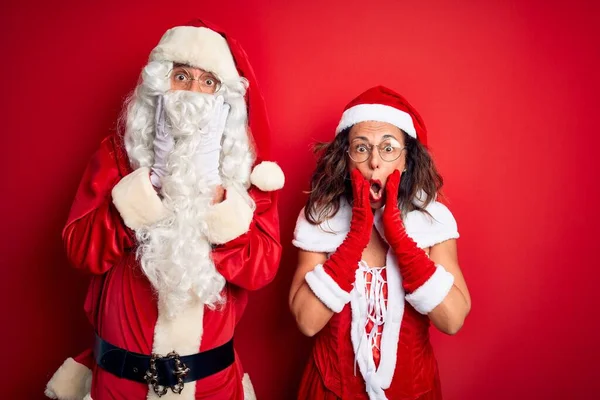 Paar Mittleren Alters Weihnachtsmannkostüm Und Brille Vor Isoliertem Rotem Hintergrund — Stockfoto