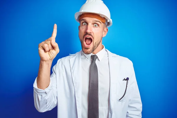 Young Handsome Engineer Man Wearing Safety Helmet Blue Isolated Background — ストック写真