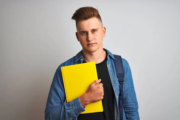 Young student man wearing denim shirt backpack notebook over isolated white background with a confident expression on smart face thinking serious
