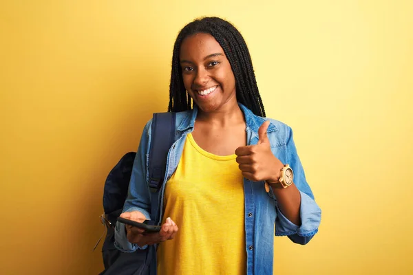 Afričanky Americká Studentka Pomocí Smartphone Stojící Nad Izolované Žluté Pozadí — Stock fotografie