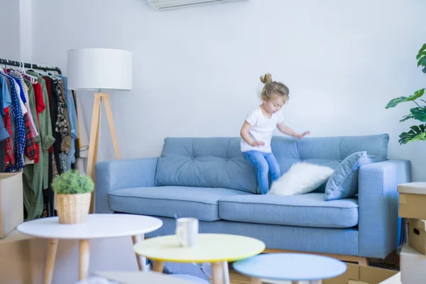 Beautiful toddler child girl jumping on the sofa