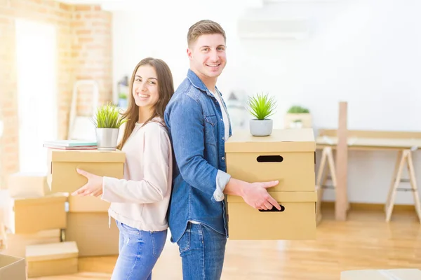 Belo jovem casal sorrindo no amor segurando caixas de papelão , — Fotografia de Stock