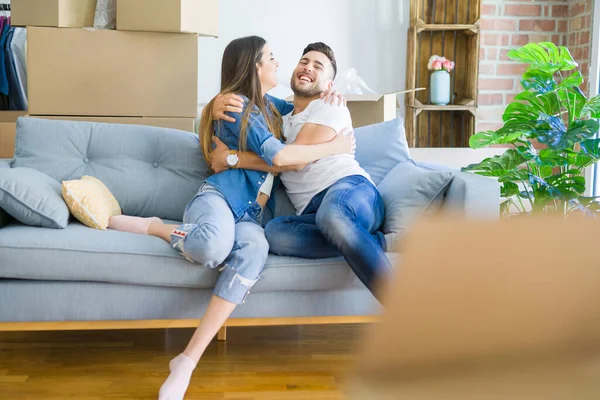 Schönes Paar, das sich verliebt auf dem Sofa umarmt, sehr glücklich lächelnd — Stockfoto