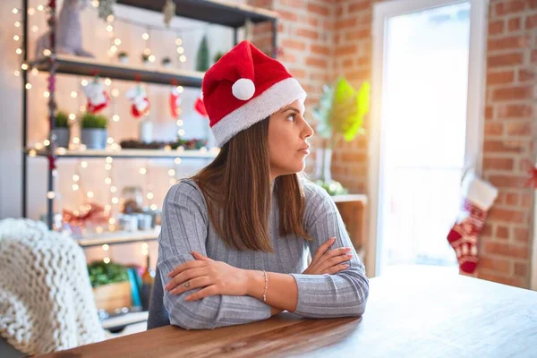 기사보기 크리스마스 모자를 아름다운 테이블에 바라보며 자신있는 미소를 스러운 얼굴로 — 스톡 사진