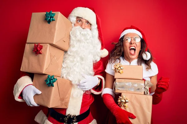 Paar Mittleren Alters Weihnachtsmannkostüm Mit Einem Turm Von Geschenken Vor — Stockfoto