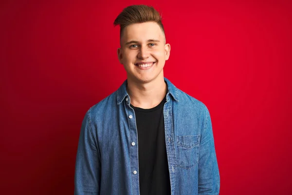 Joven Hombre Guapo Con Camisa Mezclilla Pie Sobre Fondo Rojo —  Fotos de Stock