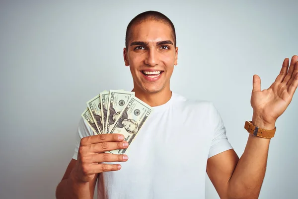 Νεαρός Όμορφος Άνδρας Κρατώντας Δολάρια Πάνω Από Λευκό Απομονωμένο Φόντο — Φωτογραφία Αρχείου